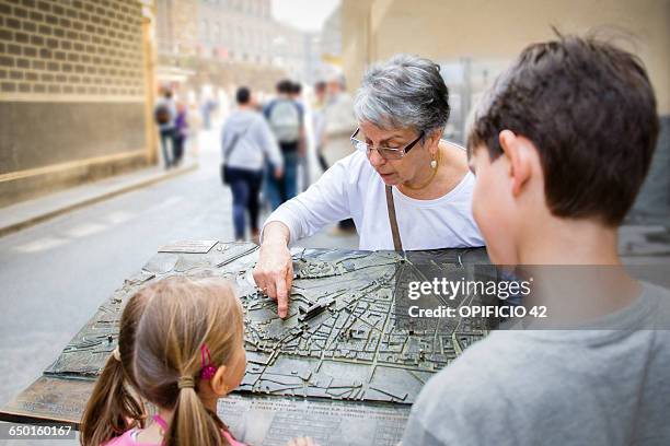 senior woman and grandchildren pointing at city map, florence, italy - map of florence italy bildbanksfoton och bilder