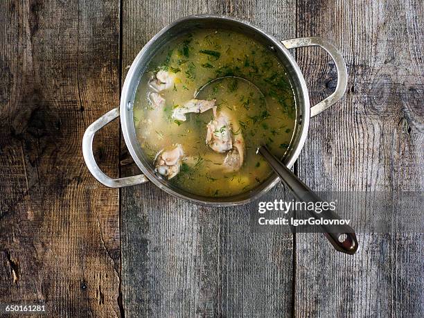 saucepan of chicken soup on wooden table - bouillon stock pictures, royalty-free photos & images