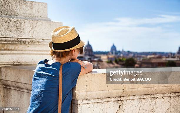 young woman from behind, leaning on a low wall, and the city of rome - mit ellenbogen gestützt stock-fotos und bilder