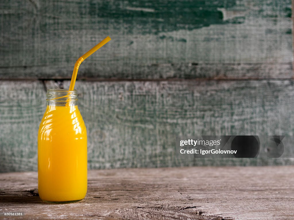 Bottle of Freshly squeezed orange juice  on wooden table