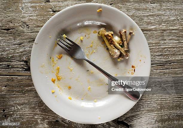 dirty plate with leftover chicken bones - dierlijk bot stockfoto's en -beelden
