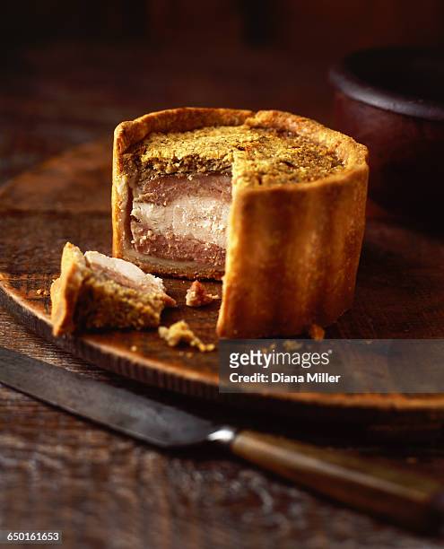 raised chicken and pork pie on wooden chopping board, close-up - pork pie stock pictures, royalty-free photos & images