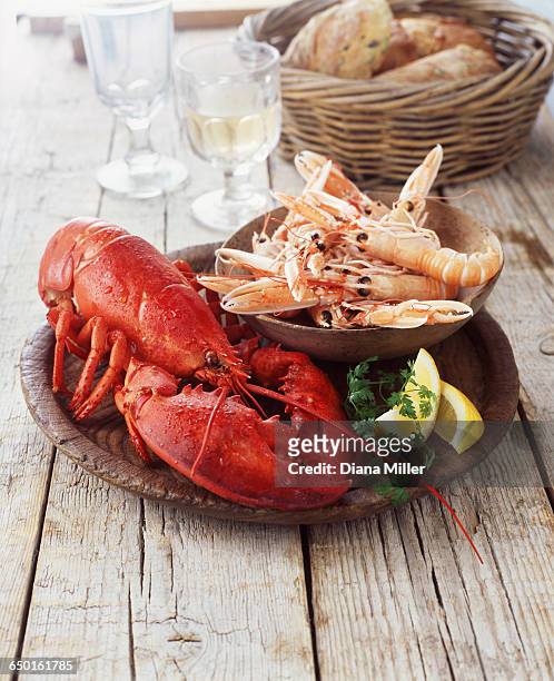 plate of lobster and prawns with wicker basket of bread - wine basket stock pictures, royalty-free photos & images