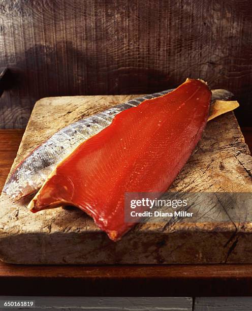 smoked side of salmon on wooden chopping board - smoked salmon stock pictures, royalty-free photos & images