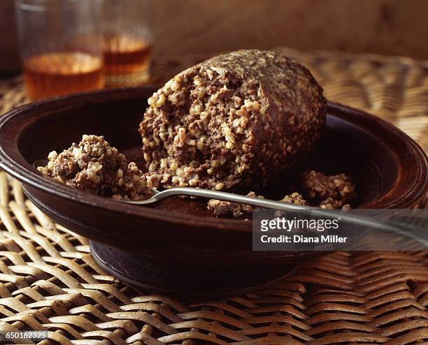 haggis in bowl on wicker place mat with glasses of whiskey - haggis stock-fotos und bilder