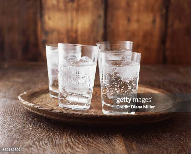 sparkling water in drinking glass with ice on vintage wooden plate - koolzuurhoudend water stockfoto's en -beelden