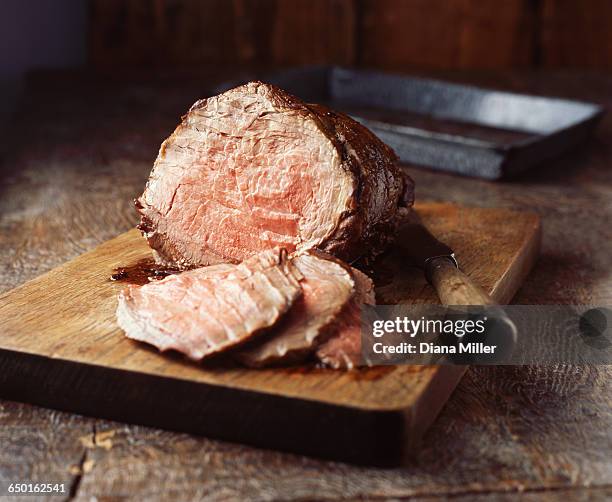 sirloin of beef on wooden cutting board - bratengericht stock-fotos und bilder