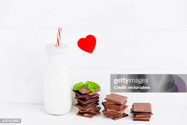 bottle of milk with stack of chocolate - chocolate milk bottle stock pictures, royalty-free photos & images