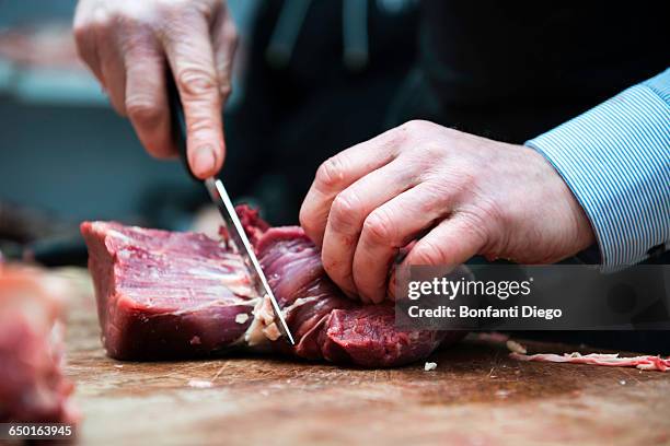 butcher preparing meat in butchers shop, close-up - slagerij stockfoto's en -beelden