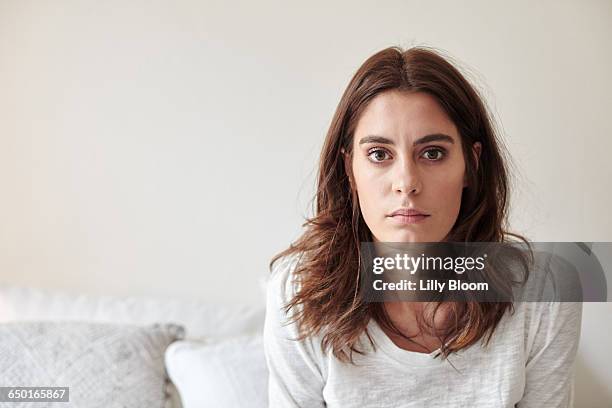 portrait of young woman staring at camera - pessimisme stock pictures, royalty-free photos & images