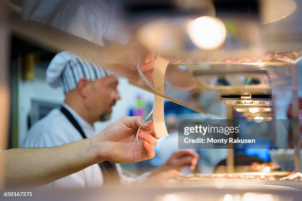 chef checking order in traditional italian restaurant kitchen - otley stock pictures, royalty-free photos & images