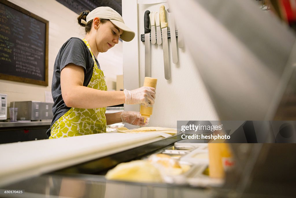 Employee in general store preparing food in kitchen
