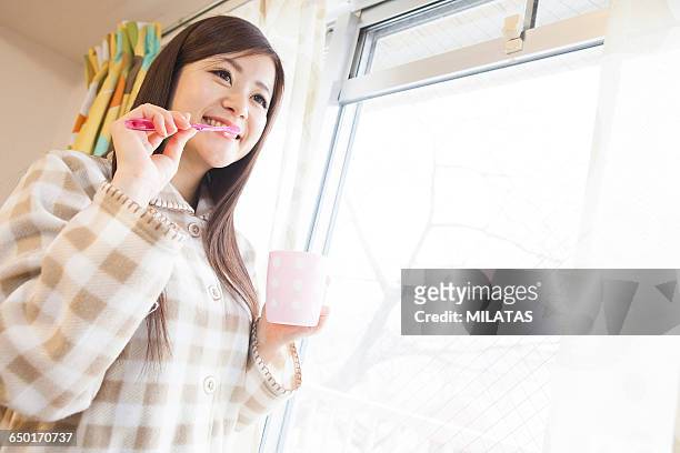 japanese women toothpaste at the window - dentifrice stockfoto's en -beelden