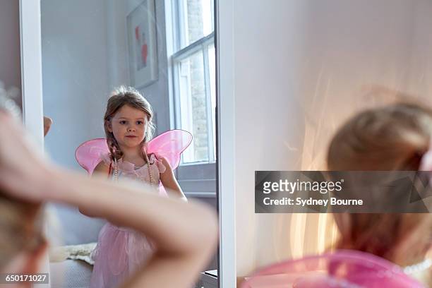 girl in fairy costume looking into mirror - feenkostüm stock-fotos und bilder