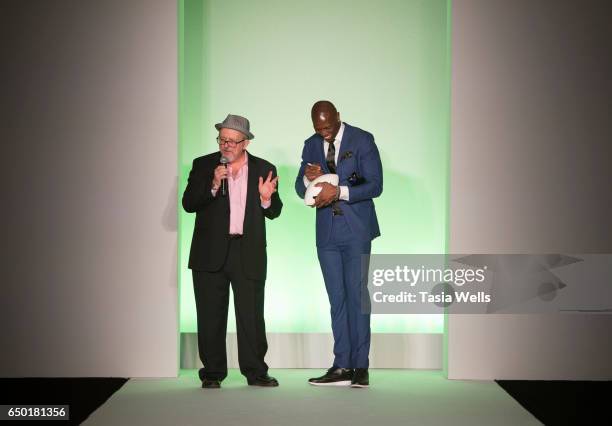 Former NFL player and sportswear designer Terrell Owens signs a football onstage at the Fashion Setters Gala at the Beverly Wilshire Four Seasons...