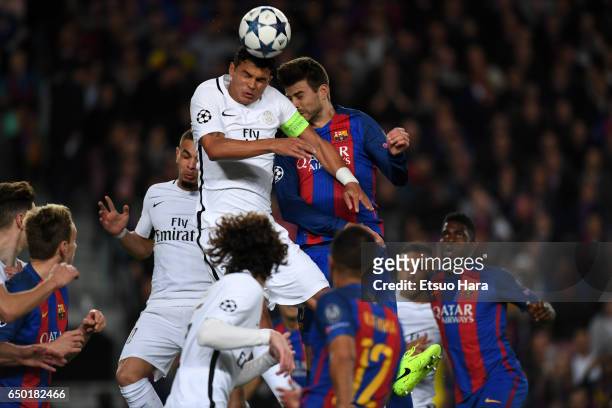 Thiago Silva of Paris Saint-Germain and Gerard Pique of Barcelona compete for the ball during the UEFA Champions League Round of 16 second leg match...