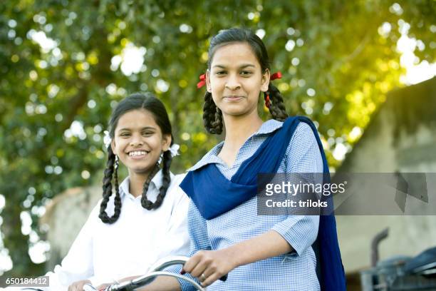 schoolgirls with bicycle - rural scene stock pictures, royalty-free photos & images