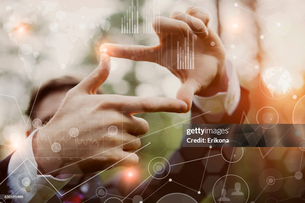 Businessman framing distant sun rays