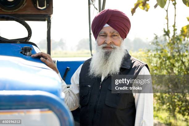 oude boer met trekker - sikhisme stockfoto's en -beelden