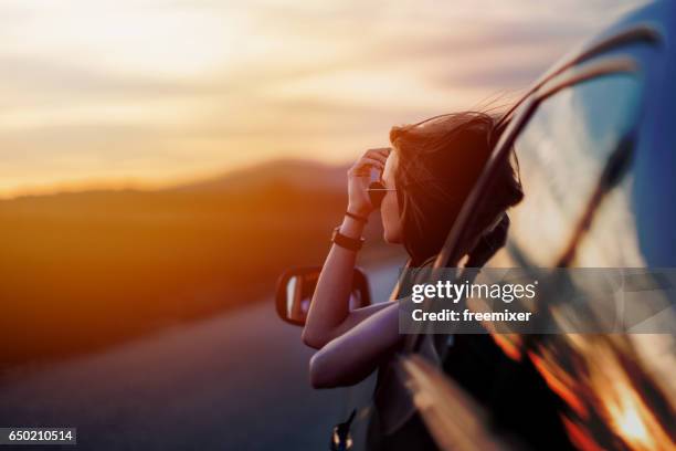 belleza en tiempo de puesta de sol - mujer conduciendo fotografías e imágenes de stock