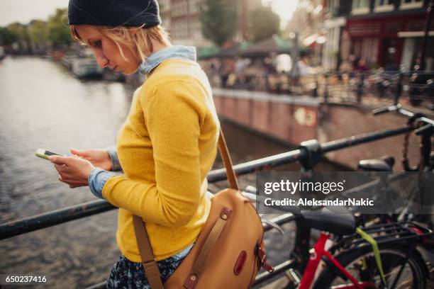 using mobile phone outdoors - amsterdam spring stock pictures, royalty-free photos & images