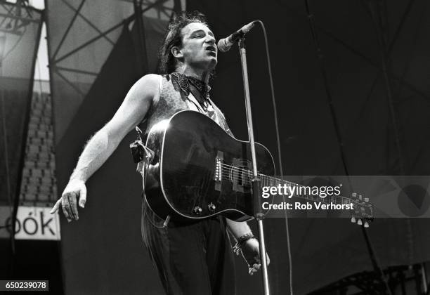 Bono of U2 performs on stage on The Joshua Tree Tour, Feyenoord Stadion, De Kuip, Rotterdam, Netherlands, 10th July 1987.