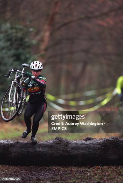 Racer lifts her bike over the log