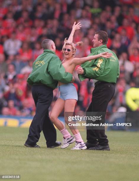 Security at the Leeds United ground remove a female streaker from the pitch