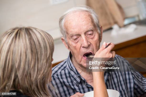 seniors having lunch in elderly day care center - feeding stock pictures, royalty-free photos & images