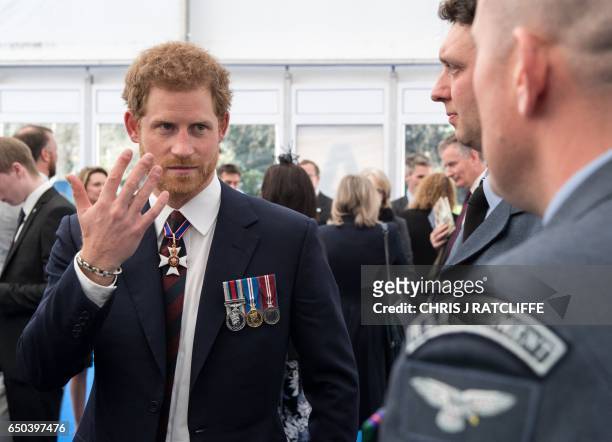 Britain's Prince Harry gestures as he speaks with British military personnel, at a reception on Horse Guards Parade in central London on March 9...