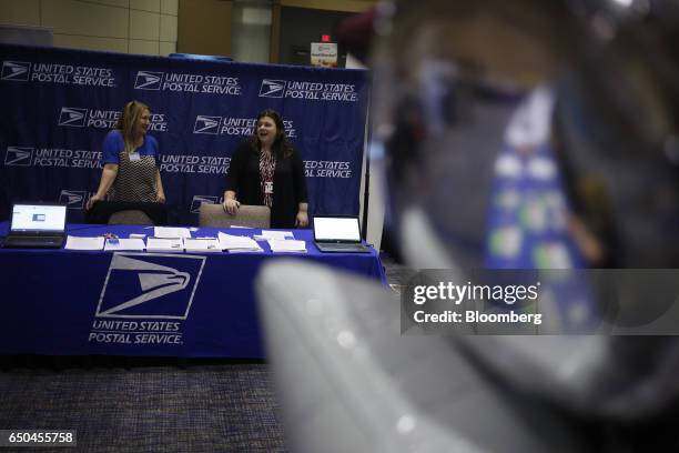 United States Postal Service recruiters wait to speak with job seekers during a Job News USA career fair in Overland Park, Kansas, U.S., on...