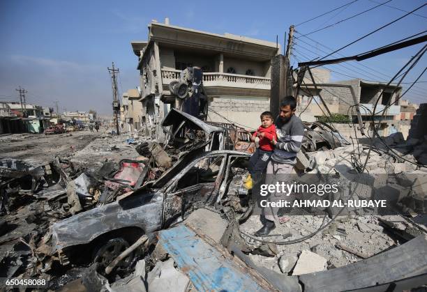An Iraqi man and a boy go through the wreckage of their home in the Shuhada neighbourhood of west Mosul, as Iraqi forces advance against Islamic...
