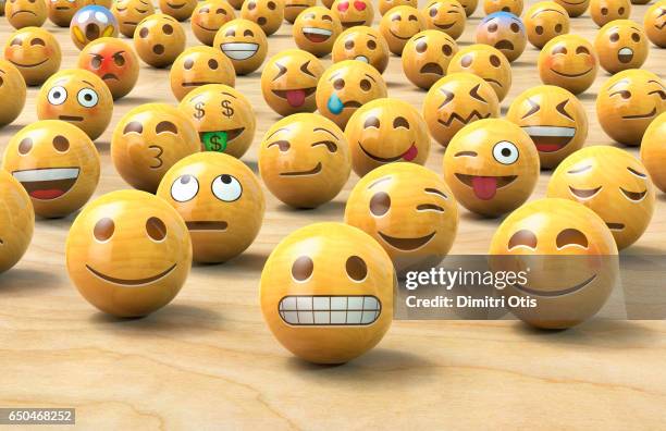 many wooden emoticon or emoji face balls, one up front - smiley stockfoto's en -beelden