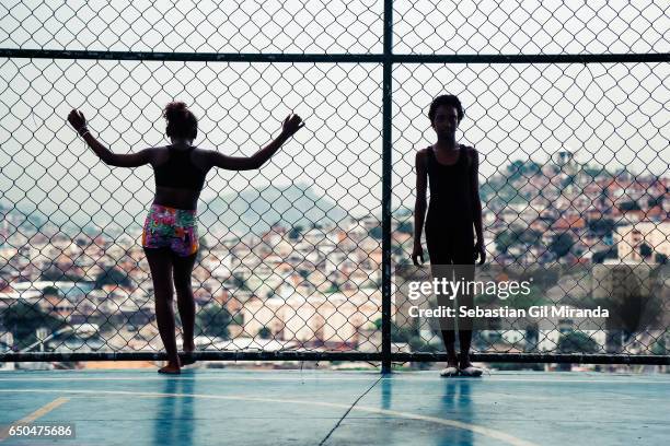 Karla and Ester, 11 years old, during a class at the multisports hall, with a view of the Complexo do Alemão.