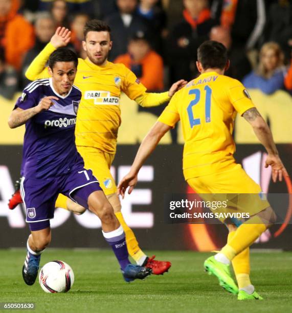 Anderlecht's Honduran midfielder Andy Najar dribbles past Apoel's Greek midfielder Giannis Gianniotas and Bulgarian defender Zhivko Milanov during...