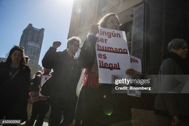 Demonstrators hold signs while marching to accompany immigration activist Ravi Ragbir, not pictured, to a check-in with Immigration and Customs...