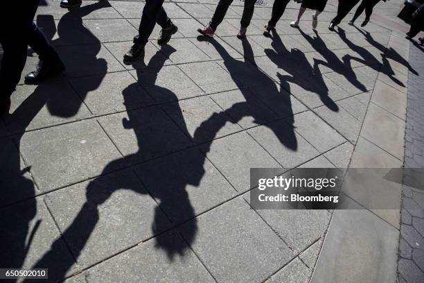 The shadows of demonstrators are seen while marching to accompany immigration activist Ravi Ragbir, not pictured, to a check-in with Immigration and...