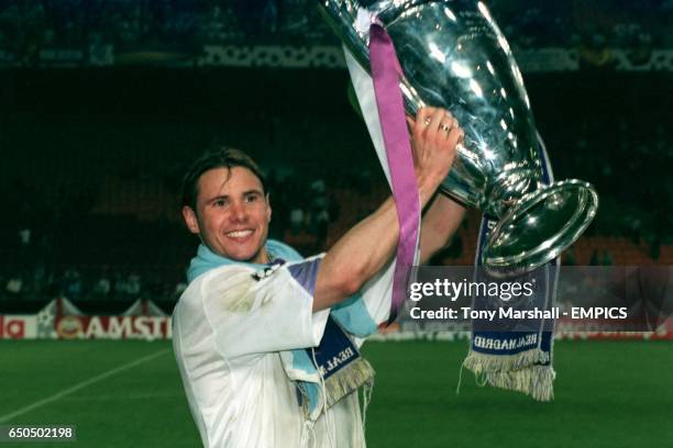 Real Madrid's Fernando Redondo lifts the trophy as he celebrates winning the match