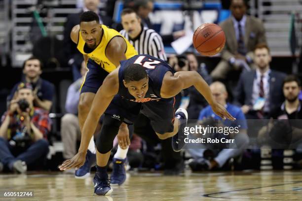 Malcolm Hill of the Illinois Fighting Illini and Zak Irvin of the Michigan Wolverines go after the ball in the first half of the Big Ten Basketball...