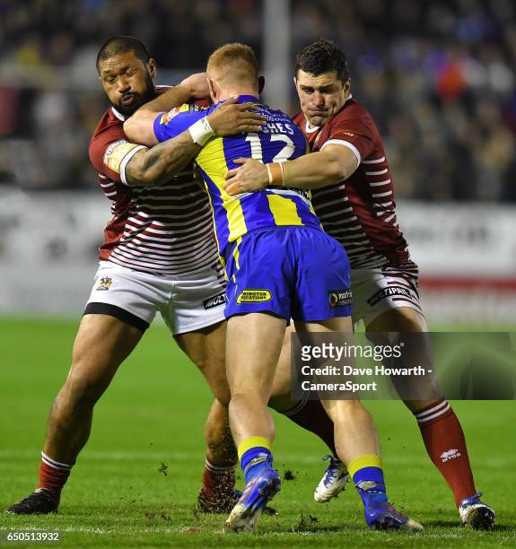 Warrington Wolves' Jack Hughes is tackled by Wigan Warriors' Ben Flower and Frank-Paul Nu'uausala during the Betfred Super League Round 4 match...