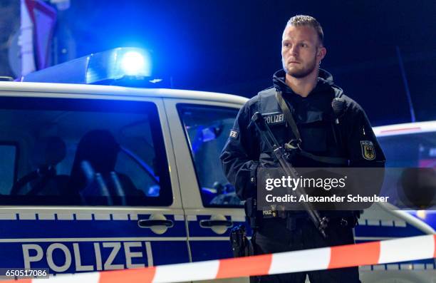 Police and emergency workers stand outside the main railway station following what police described as an axe attack on March 9, 2017 in Dusseldorf,...