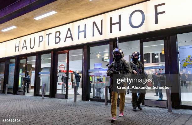 Police and emergency workers stand outside the main railway station following what police described as an axe attack on March 9, 2017 in Dusseldorf,...