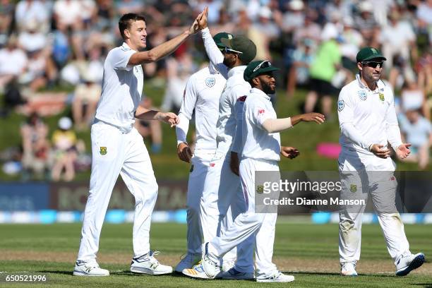 Morne Morkel of South Africa celebrates with team mates the dismissal of Jimmy Neesham of New Zealand during day three of the First Test match...