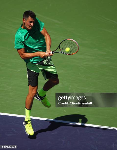 Bernard Tomic of Australia plays a backhand against Bjorn Fratangelo of the United States in their first round match during day four of the BNP...