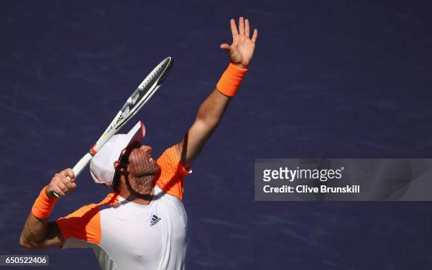 Bjorn Fratangelo of the United States serves against Bernard Tomic of Australia in their first round match during day four of the BNP Paribas Open at...