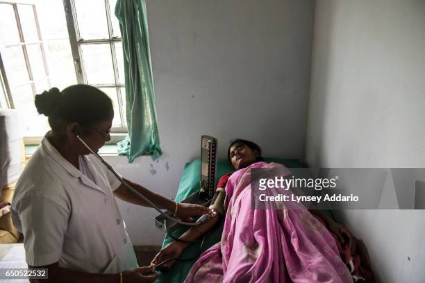 Anjita Barla who is seven months pregnant with her second child, receives a checkup from a midwife, Lucia Ekka, at a health clinic in Tinkharia tea...