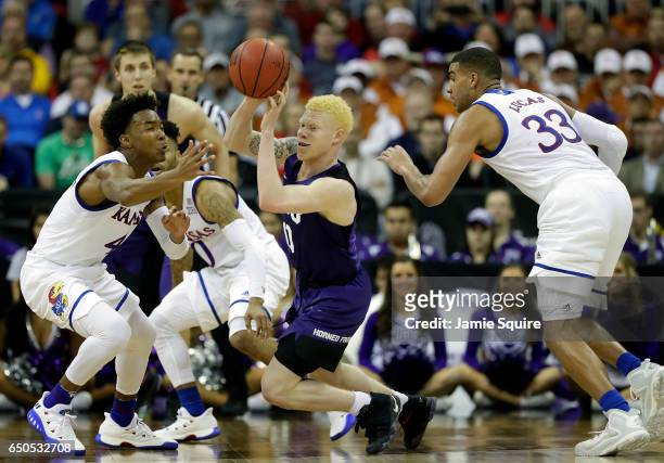 Jaylen Fisher of the TCU Horned Frogs controls the ball as Devonte' Graham of the Kansas Jayhawks defends during the quarterfinal game of the Big 12...