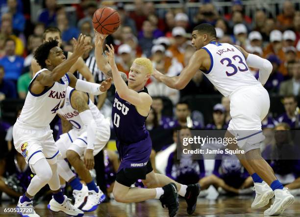 Jaylen Fisher of the TCU Horned Frogs controls the ball as Devonte' Graham of the Kansas Jayhawks defends during the quarterfinal game of the Big 12...