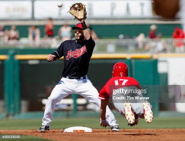 Eric Stamets of the Cleveland Indians fields a throw to second as Shane Robinson of the Los Angeles Angels of Anaheim attempts to steal in the third...