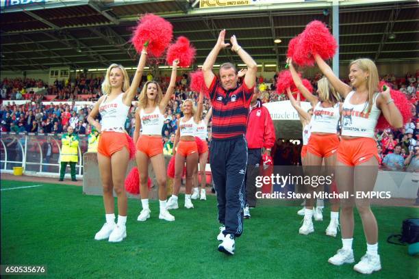 Nottingham Forest manager Dave Bassett walks out to introduce new signing Nigel Quashie to the crowd, flanked by 'Hooters' girls